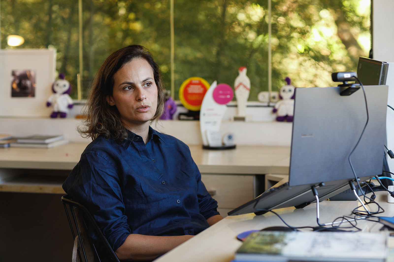 Empreendedora conversa com equipe feminina de atendimento remoto em ambiente moderno