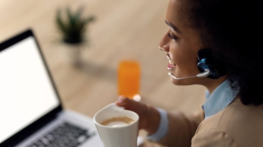 Mulher negra, Profissional de atendimento, ouvindo cliente em videoconferência com em seu escritório home office
