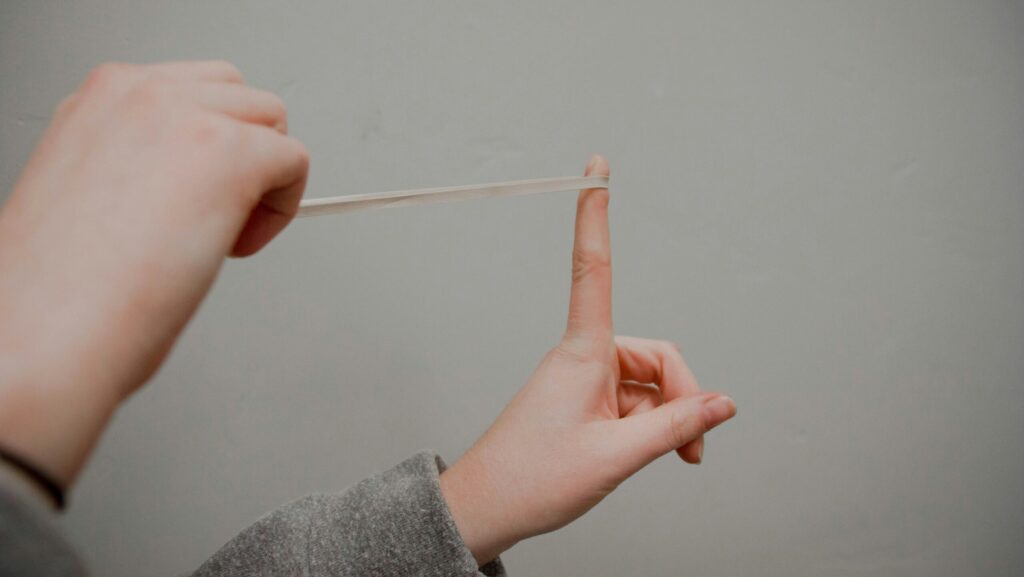 Um elástico sendo esticado para representar a elasticidade necessária para gerenciar os picos de demanda no atendimento ao cliente.