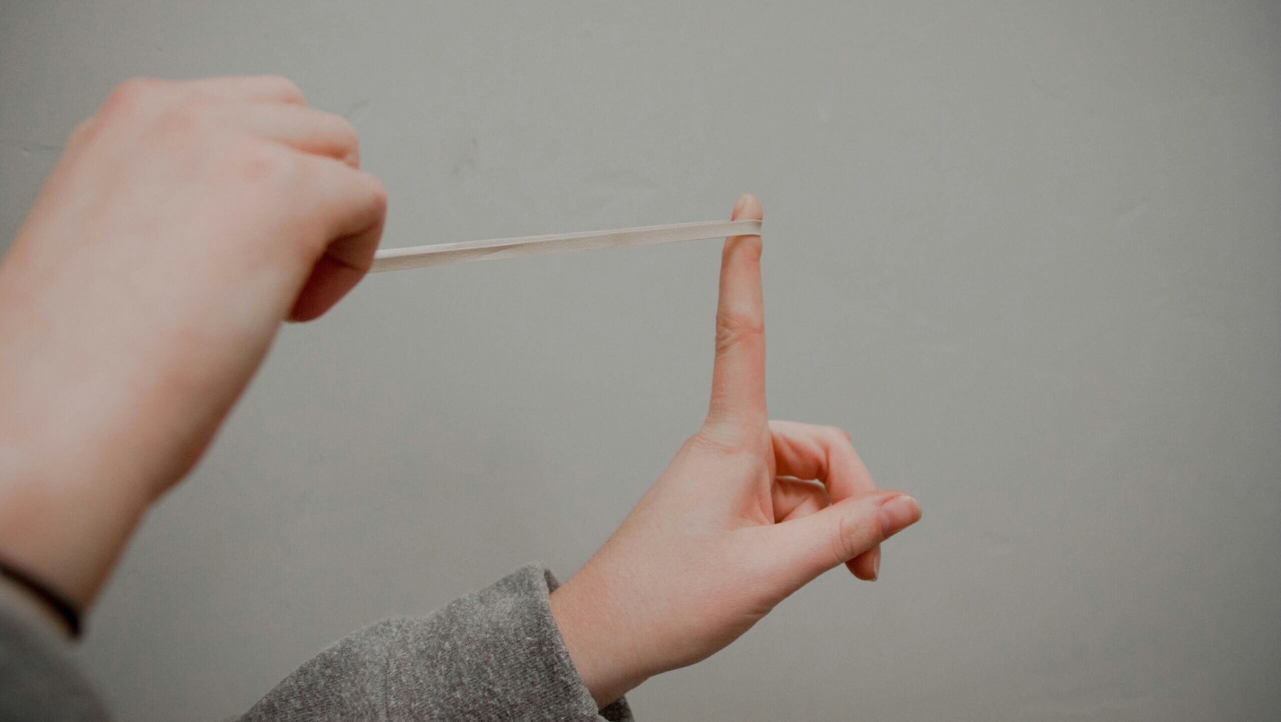 Um elástico sendo esticado para representar a elasticidade necessária para gerenciar os picos de demanda no atendimento ao cliente.